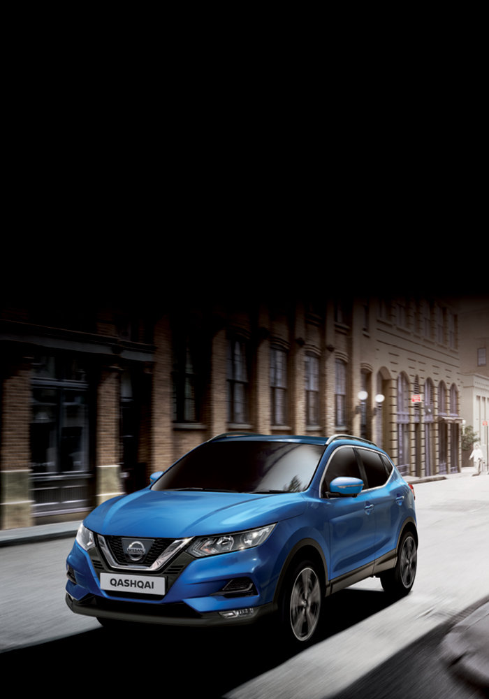 Blue Qashqai driving in between buildings